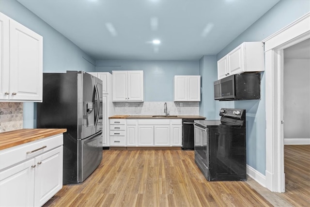 kitchen with white cabinets, light wood-type flooring, backsplash, and black appliances