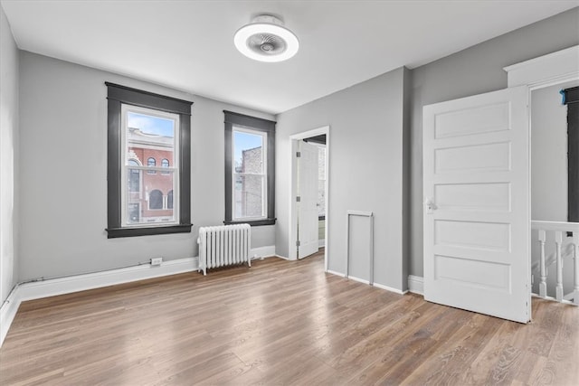 unfurnished bedroom featuring hardwood / wood-style floors and radiator