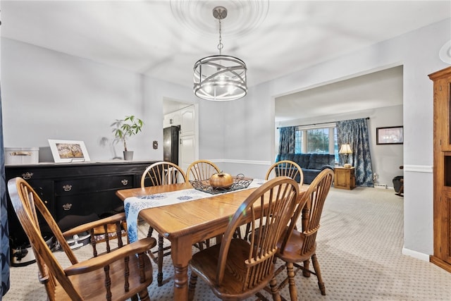 carpeted dining room with an inviting chandelier