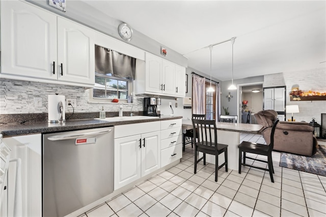 kitchen featuring white cabinetry, stainless steel dishwasher, and decorative light fixtures