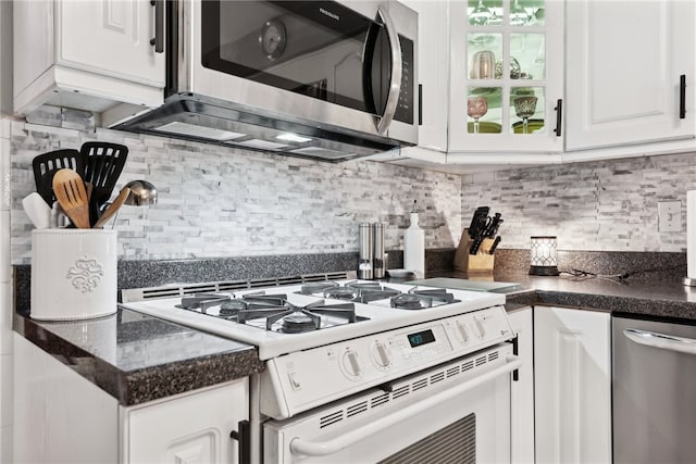 kitchen with backsplash, white cabinets, and stainless steel appliances