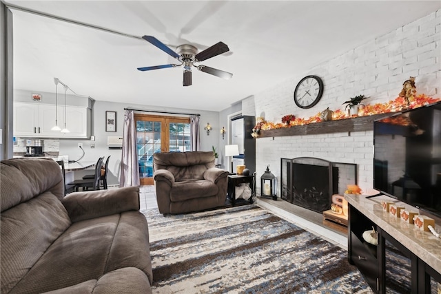 living room with ceiling fan, french doors, brick wall, and a brick fireplace