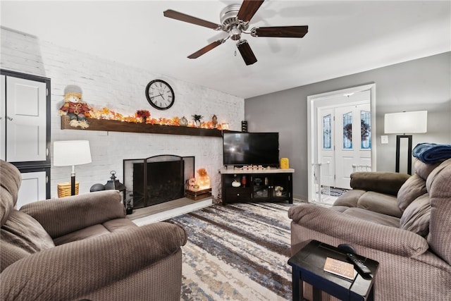 living room with ceiling fan and a fireplace