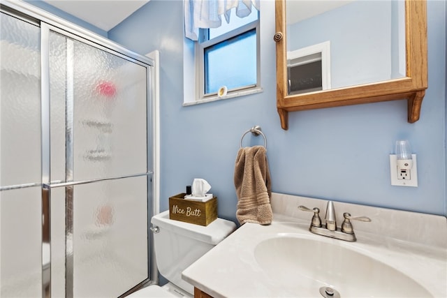 bathroom with walk in shower, vanity, and toilet