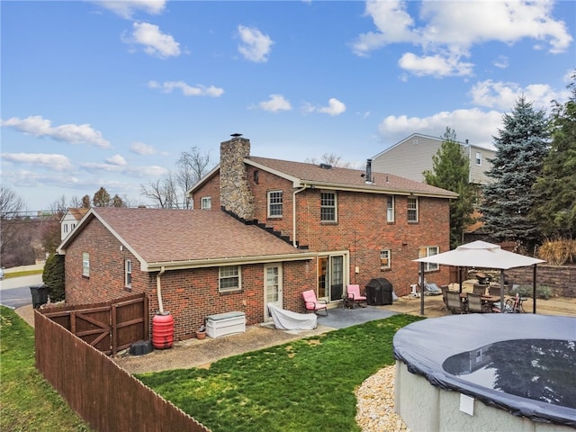 rear view of house featuring a yard, a patio, and a covered pool