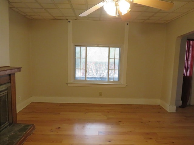 unfurnished living room featuring a paneled ceiling, light hardwood / wood-style flooring, and ceiling fan