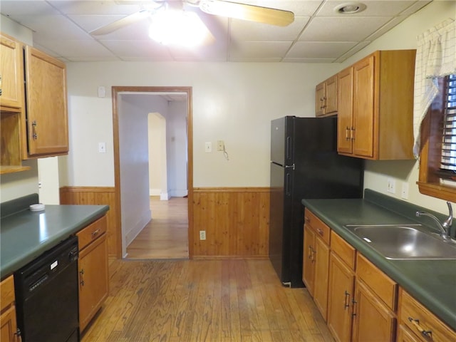 kitchen featuring light wood-type flooring, a drop ceiling, ceiling fan, sink, and black appliances