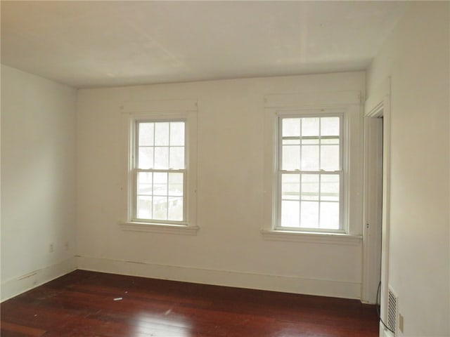 unfurnished room with a healthy amount of sunlight and dark hardwood / wood-style floors