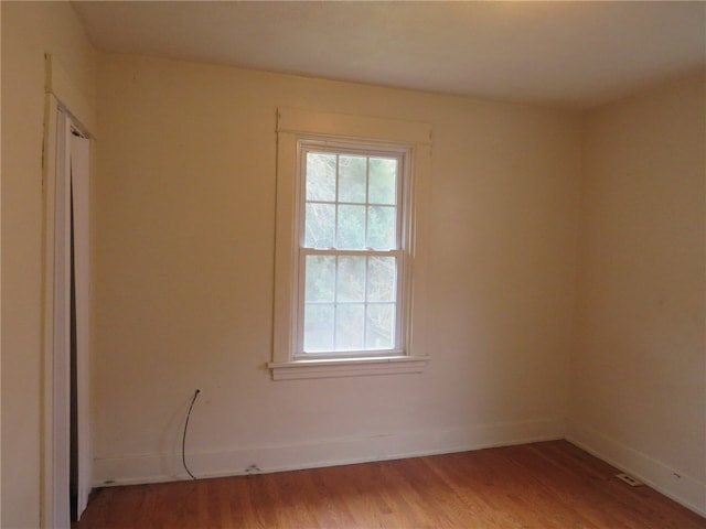 unfurnished room with hardwood / wood-style flooring