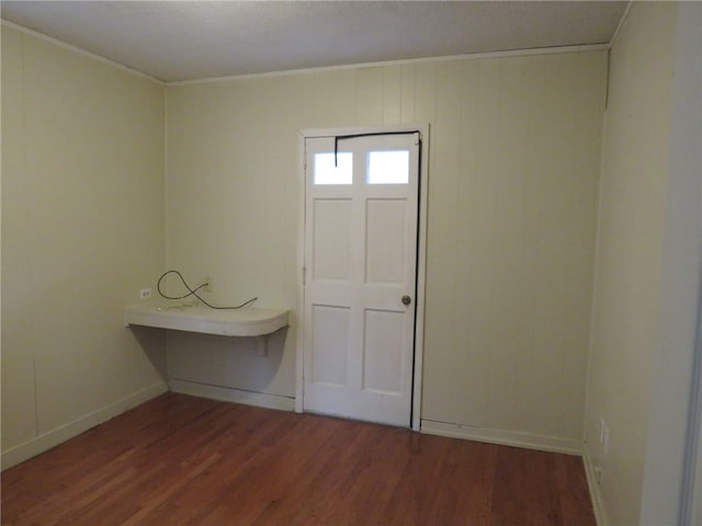 interior space with dark hardwood / wood-style flooring and ornamental molding