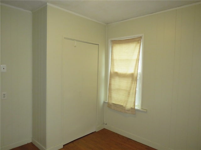 empty room featuring crown molding and dark wood-type flooring