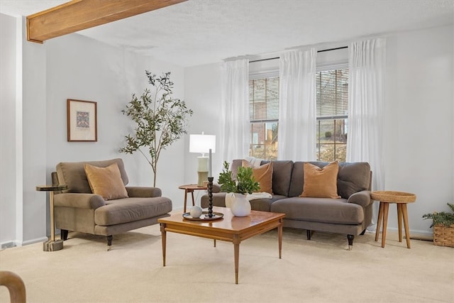 sitting room with beam ceiling and light colored carpet