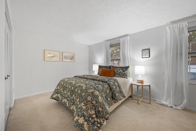 carpeted bedroom featuring a textured ceiling and a closet