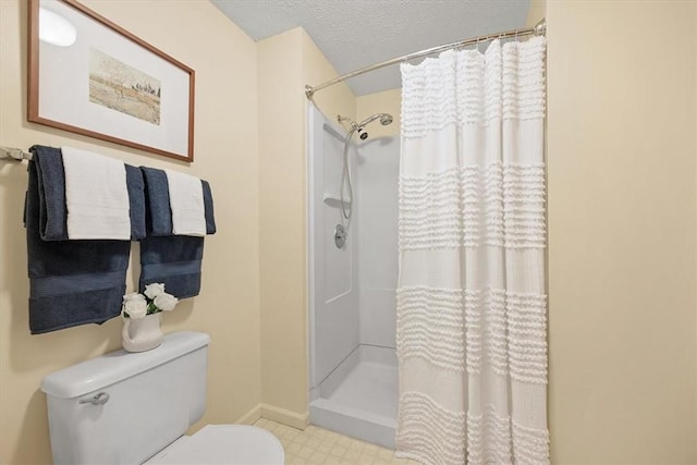 bathroom featuring curtained shower, toilet, and a textured ceiling