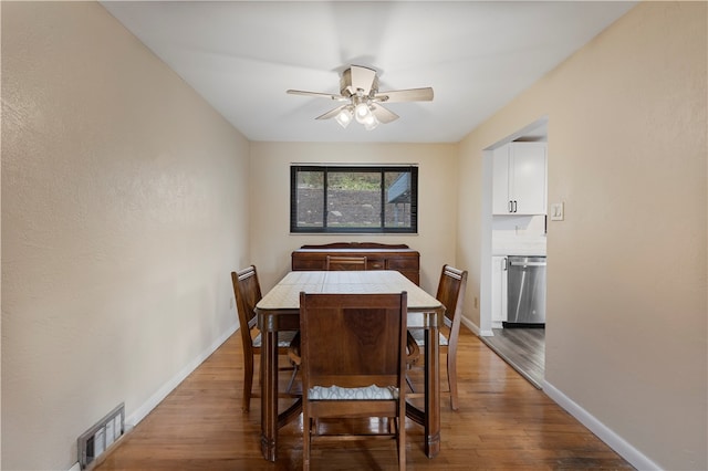 dining area with wood-type flooring and ceiling fan