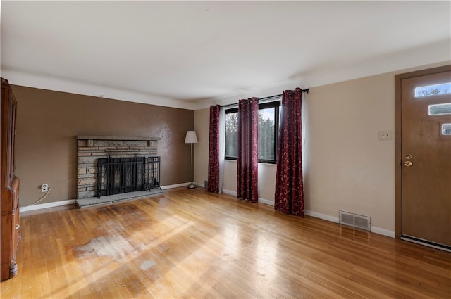 unfurnished living room with hardwood / wood-style floors, a healthy amount of sunlight, and a fireplace