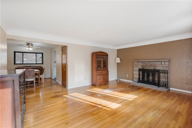 living room with a fireplace, hardwood / wood-style flooring, and ceiling fan