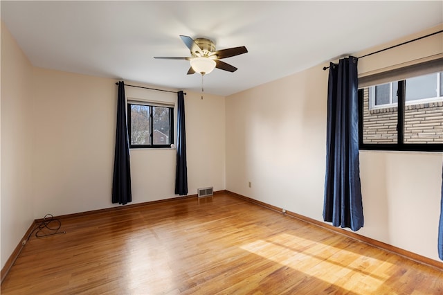 unfurnished room with hardwood / wood-style floors, plenty of natural light, and ceiling fan