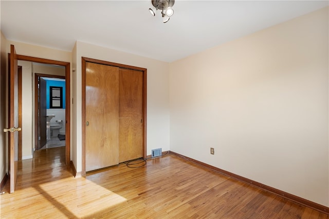 unfurnished bedroom with light hardwood / wood-style flooring and a closet