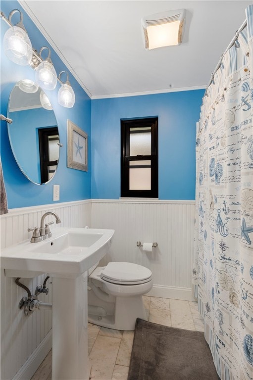 bathroom featuring crown molding and toilet