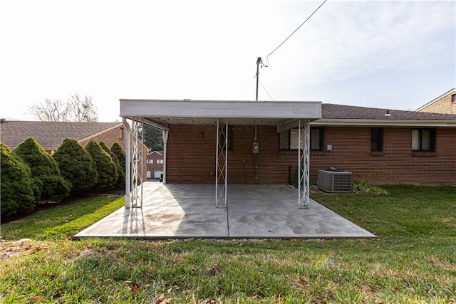 back of house with a yard, a carport, and central air condition unit