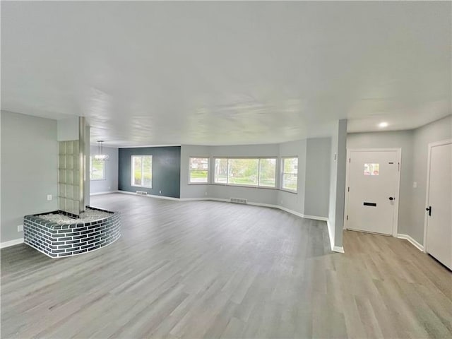 unfurnished living room with a fireplace and light hardwood / wood-style floors