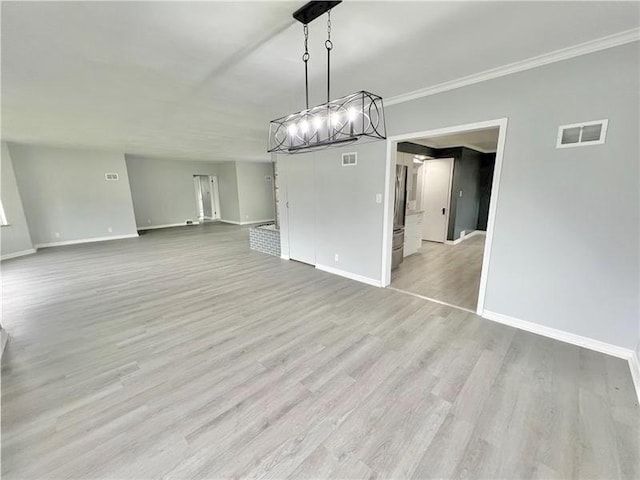 unfurnished dining area featuring light hardwood / wood-style floors and ornamental molding