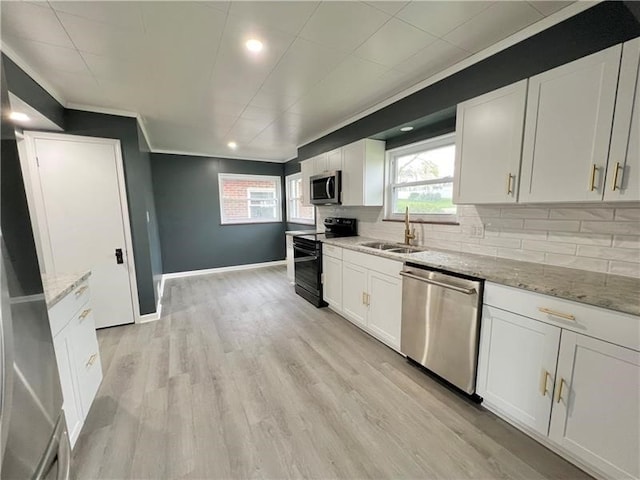 kitchen featuring light stone countertops, stainless steel appliances, white cabinetry, and sink