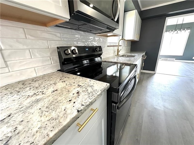 kitchen with white cabinets, sink, light hardwood / wood-style flooring, electric range, and light stone counters