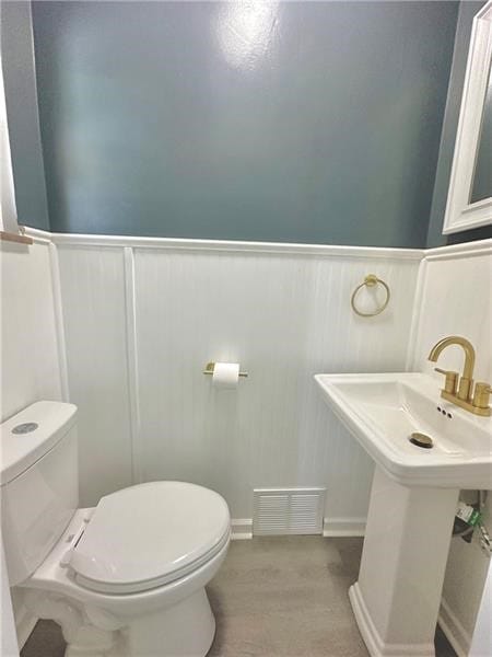 bathroom with hardwood / wood-style flooring, toilet, and sink