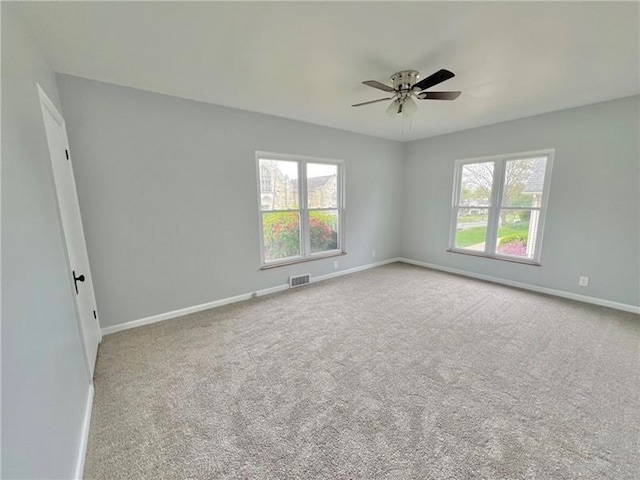 spare room featuring light carpet and ceiling fan