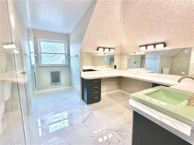 bathroom featuring a shower with door, vanity, tile walls, and toilet