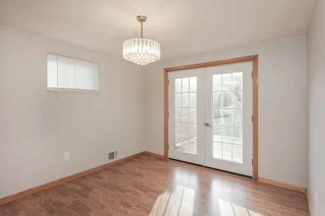 entryway with french doors, wood-type flooring, and a notable chandelier