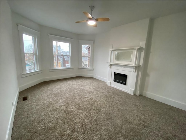 unfurnished living room with carpet flooring and ceiling fan