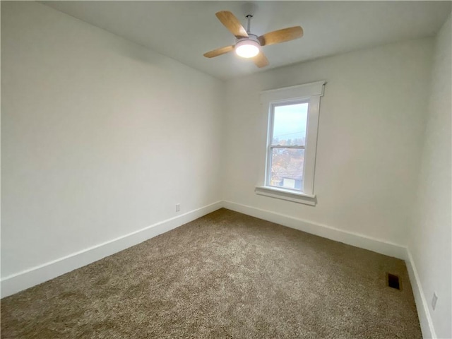 carpeted spare room with ceiling fan