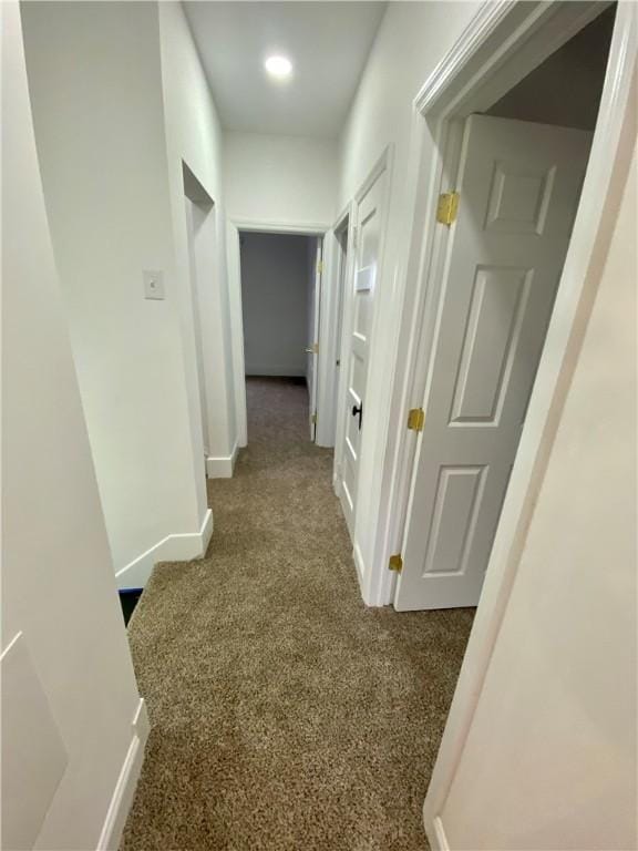 hallway featuring dark carpet