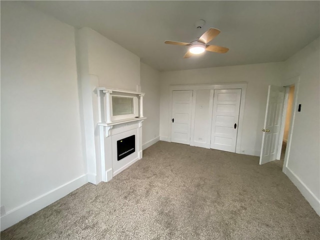 unfurnished living room featuring carpet and ceiling fan