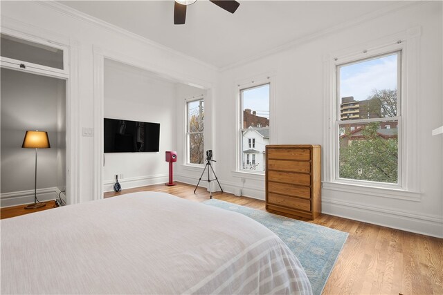 bedroom with ceiling fan, light hardwood / wood-style flooring, and crown molding