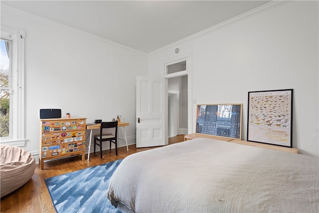 bedroom with hardwood / wood-style flooring and ornamental molding