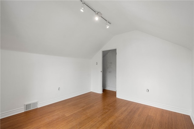 additional living space featuring wood-type flooring and lofted ceiling