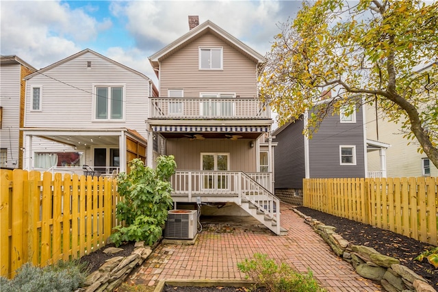 back of house featuring central AC, a patio area, and a balcony