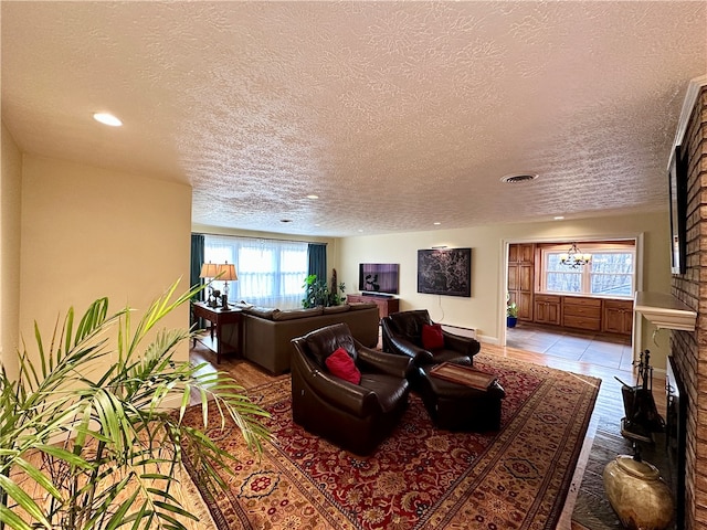 living room featuring baseboard heating, light tile patterned floors, a healthy amount of sunlight, and a textured ceiling