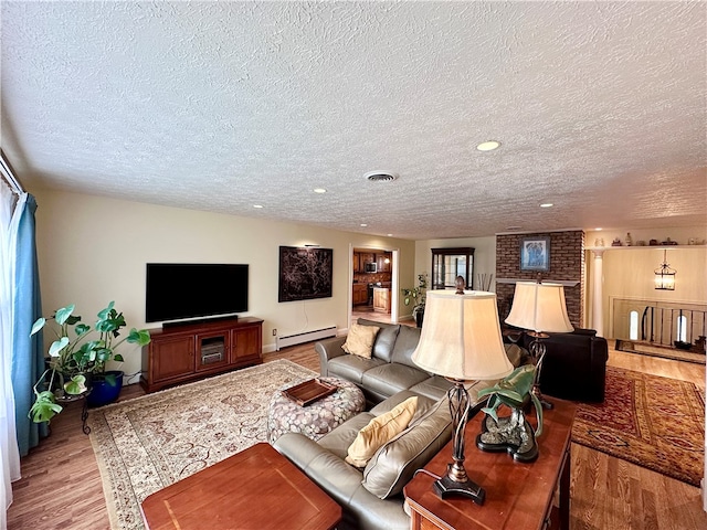 living room with wood-type flooring, a textured ceiling, and a baseboard radiator