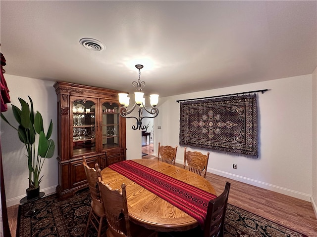 dining room with a chandelier and dark wood-type flooring