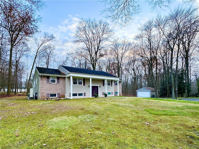 split foyer home with a porch, a front yard, an outdoor structure, and a garage