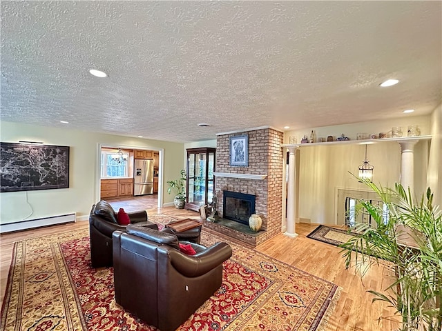 living room with a fireplace, wood-type flooring, a textured ceiling, and baseboard heating