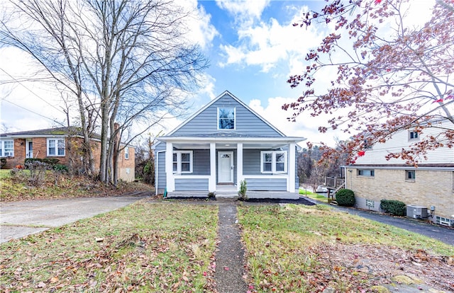 bungalow with cooling unit and a front yard