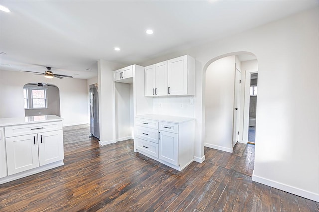 kitchen with ceiling fan, white cabinets, and dark hardwood / wood-style floors