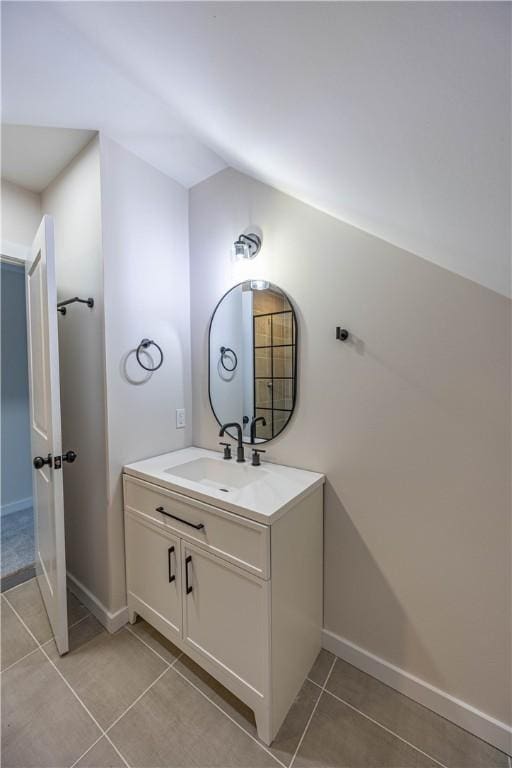 bathroom with vanity, tile patterned floors, and lofted ceiling