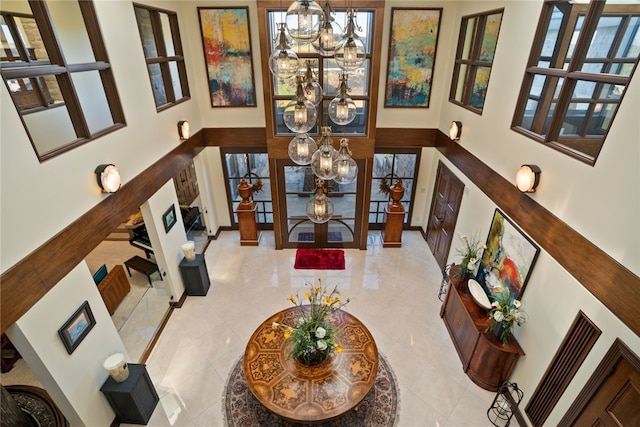 interior space with french doors, a high ceiling, and an inviting chandelier